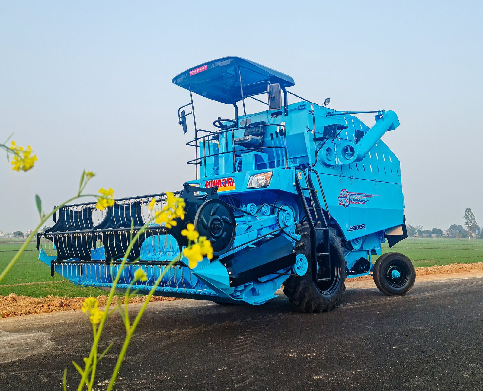 A second front view of the Mini combine in a field.